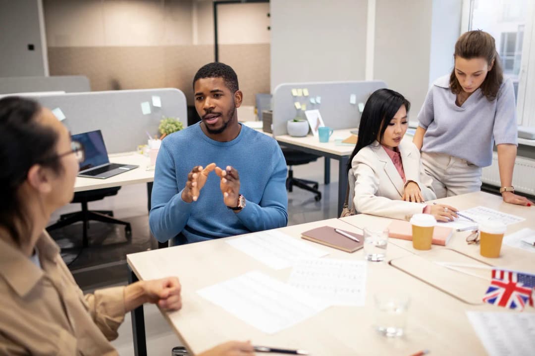 A team of Rankupper employees gathered around a table in an office, engaged in discussion and collaboration.