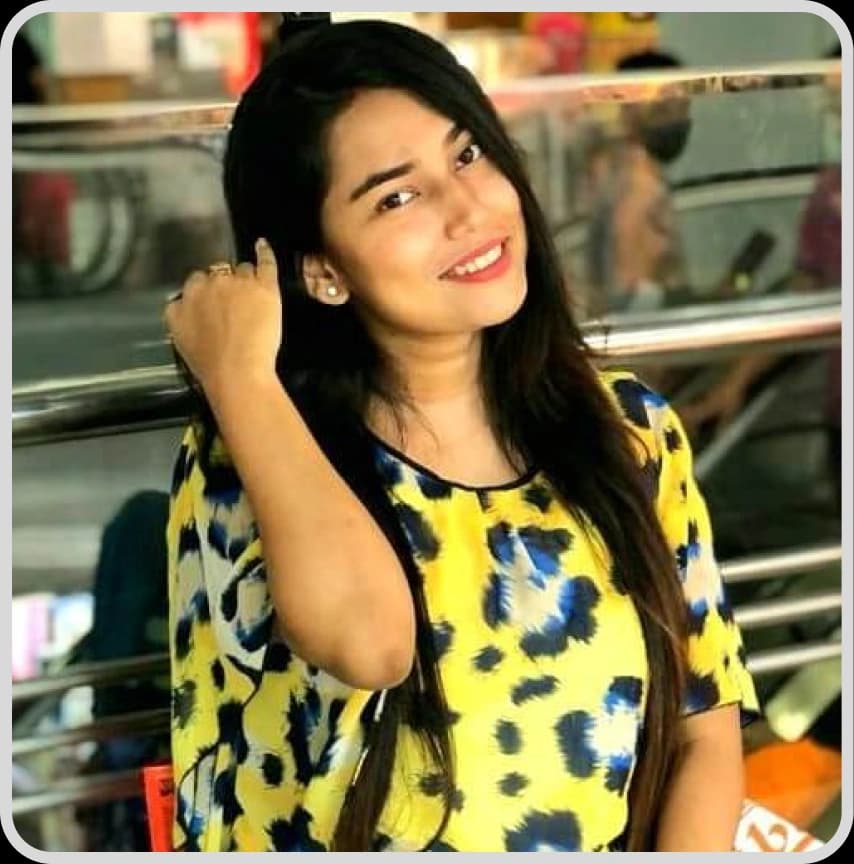 A woman in a blue shirt stands with arms crossed, representing Client Support Ashfia Hiya from Rankupper.