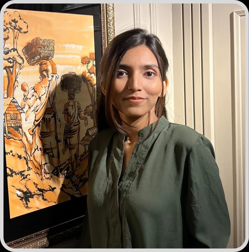 A woman in a blue shirt stands with arms crossed, representing Mashiya Jeba, Business Development Executive at Rankupper.